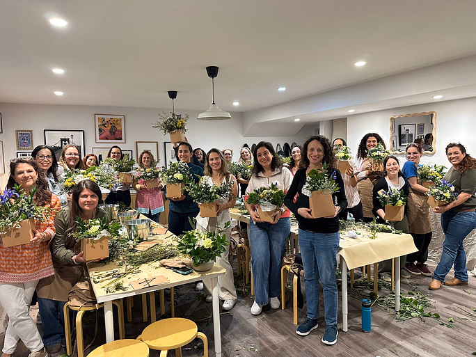 Women participating in Israel through the Six Senses series hold bouquets of flowers from Shavuot flower arranging workshop.