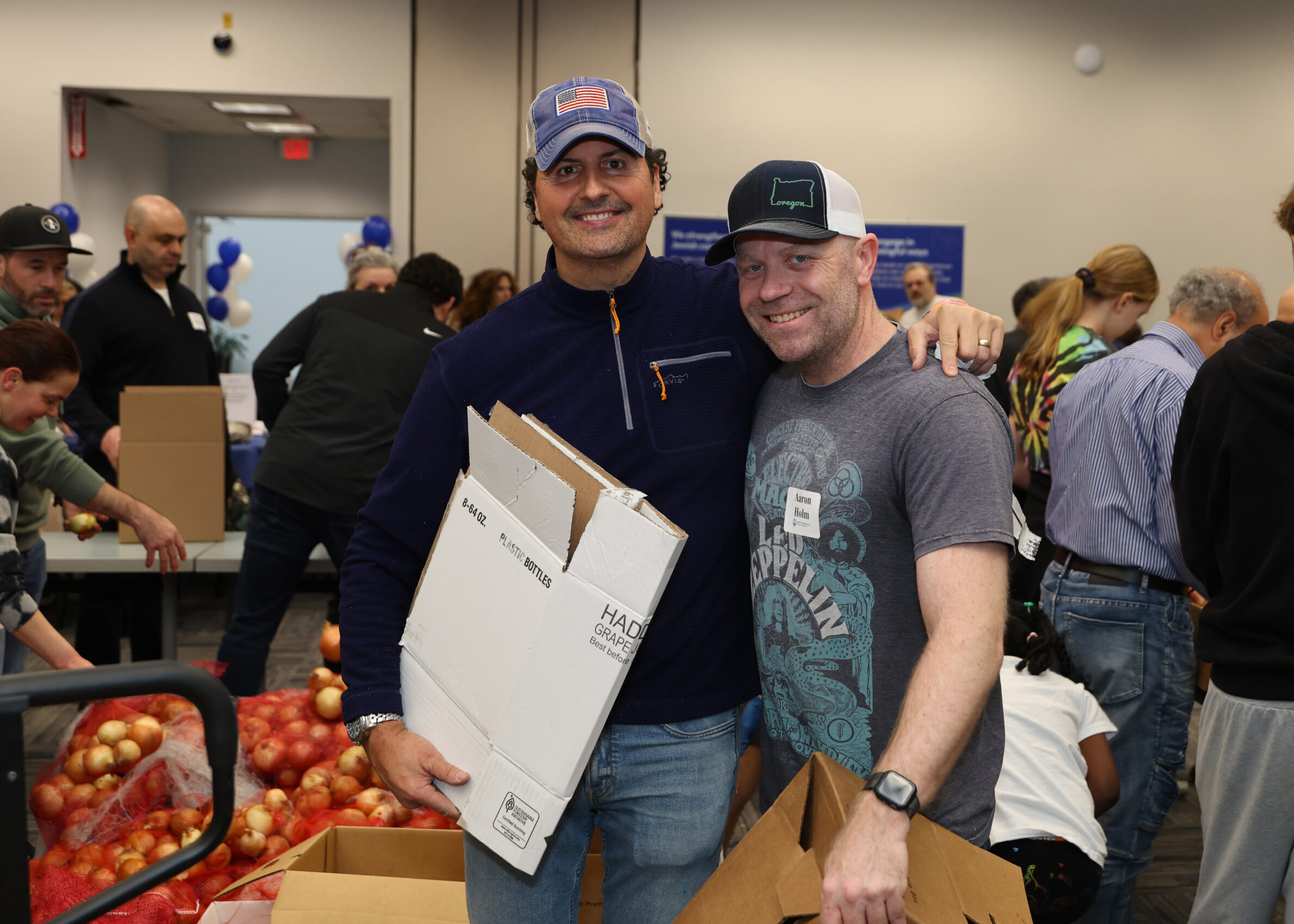 Men packing boxes of food to feed our community during Food Insecurity Awareness Month this November