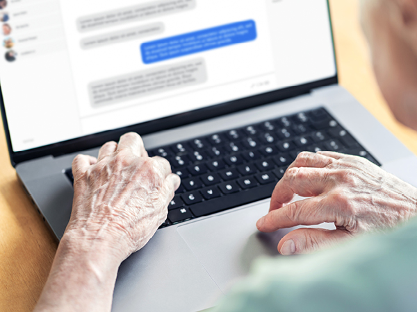 Elderly person sending DMs on a laptop